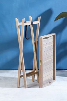 a pair of wooden folding chairs next to a blue wall