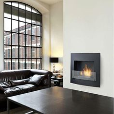 a living room with couches and a fire place in the wall next to a window