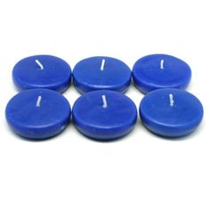 six blue candles sitting on top of each other with one lit candle in the middle