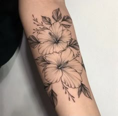 a black and white flower tattoo on the arm