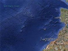 an image of a satellite view of the ocean and land in front of it,