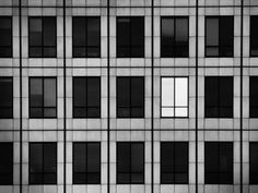 an abstract black and white photo of a building's windows with the word art com written on it