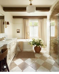 a bathroom with checkered tile flooring and white walls, along with a large bathtub