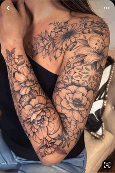 a woman's arm with flowers on it and her hand resting against her elbow