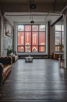 an empty room with two couches and a large window