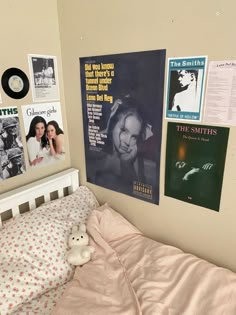 a bedroom with posters on the wall and a small bed in front of it's headboard