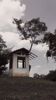 a small tower sitting on top of a lush green hillside