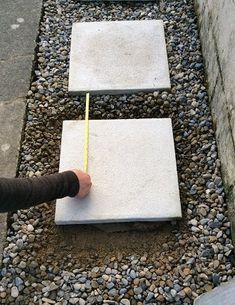 someone is measuring the area between two concrete blocks