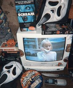 an old television sitting on top of a table next to some movies and other items