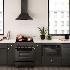 a stove top oven sitting inside of a kitchen next to a counter with pots and pans on it