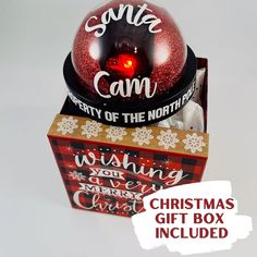 a christmas gift box with a red light in it and the words, santa cam city of the north pole