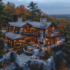 this is an aerial view of a house in the woods at night with its lights on