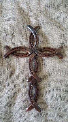 a cross made out of metal sitting on top of a white cloth