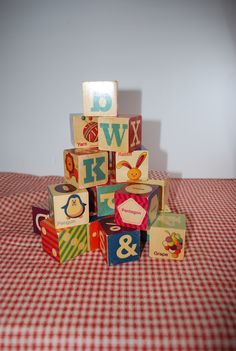 a pile of wooden blocks sitting on top of a red and white checkered table cloth