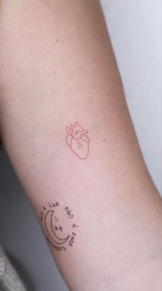 a woman's arm with a heart and moon tattoo on the left side of her arm