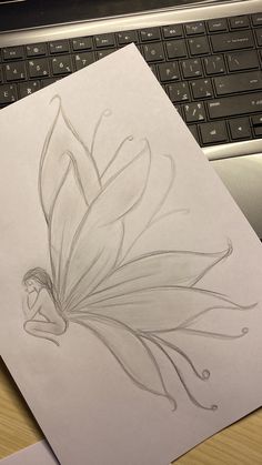 a drawing of a flower on paper next to a computer keyboard