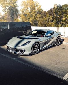 a silver sports car parked next to a black truck