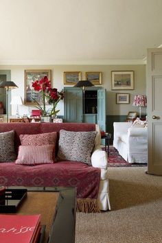 a living room filled with lots of furniture and decor on top of carpeted flooring