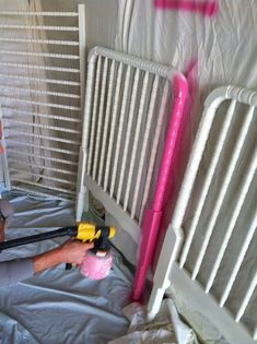 a man laying on top of a bed next to a pink and yellow blow dryer