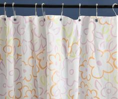 a shower curtain with an orange and pink flower pattern on it, hanging from a metal rod