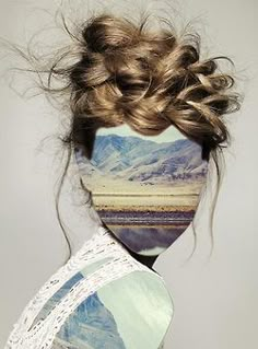 a woman's face with her hair in a messy bun and mountains behind her