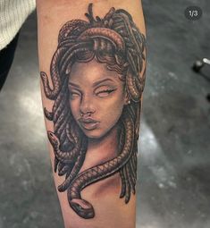 a woman's head with a snake wrapped around it on the arm and behind her