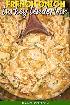 chicken noodle soup in a crock pot with a wooden spoon on the side