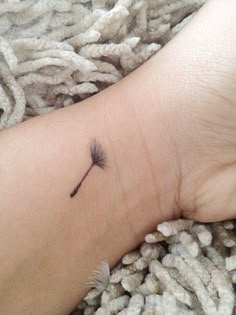 a small dandelion tattoo on the wrist