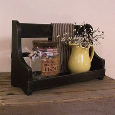 a vase with flowers in it sitting on a wooden shelf next to a striped towel