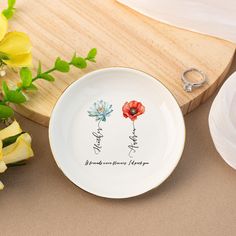 a white plate with two flowers on it next to a knife and flower potted plant