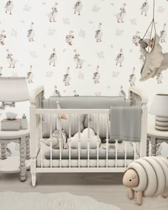 a baby's room with white furniture and wallpaper