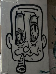 a drawing of a man's face on the side of a wall with graffiti