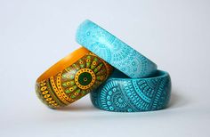 three colorful rings with designs on them sitting in front of a white background or wall