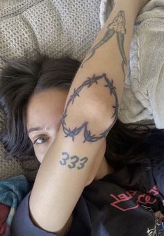 a woman laying on top of a bed with her arm wrapped in barbed wire and the number 33