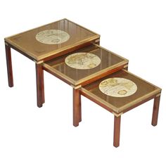 a set of three tables with glass top and wooden legs, each topped with a map