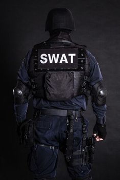 the swat officer is standing with his back to the camera