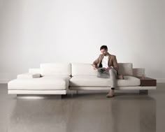 a man sitting on top of a white couch