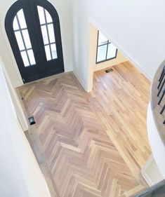 an aerial view of a house with wood flooring and black door, taken from above