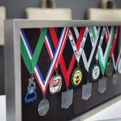 a group of medals hanging from the side of a metal frame on top of a table