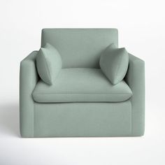 a light green chair with two pillows on the armrests and one pillow on the back