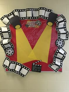 a paper cut out of a red and yellow shirt hanging on a white brick wall