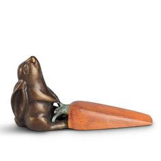 a metal figurine with a carrot shaped like a dog