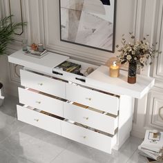 a white dresser with drawers and candles on it