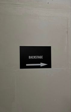 a black and white sign that says backstage with an arrow pointing towards the back stage