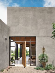 an open door leading to a patio with potted plants