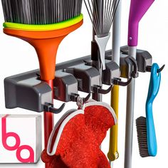 there are many different types of cleaning supplies on this rack, including brooms and brushes