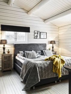 a bedroom with white walls and wooden floors