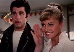 a man and woman standing next to each other in front of a kitchen counter top