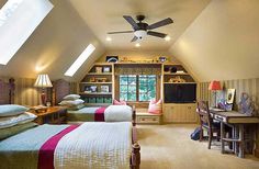 a bedroom with two beds and a desk in the corner under a slanted ceiling