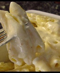 a fork is being used to eat macaroni and cheese